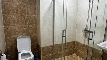 Een douche, handdoeken, zeep, shampoo