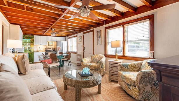 A spacious living area with a high ceiling, wooden beams, a dining table, and comfortable seating. - Oh So Sandy! - Southern Shores, Historic Flat Top, 100 Yds to Beach, Pets OK, Flex Stays (Southern Shores)