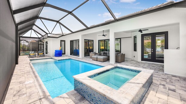 Un espace piscine intérieur moderne doté d’un toit en verre, d’un jacuzzi et d’un espace détente extérieur.