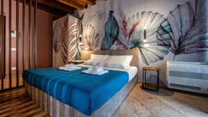 Et hotelværelse med en stor seng, et vægmaleri, et træloft og en moderne aircondition.