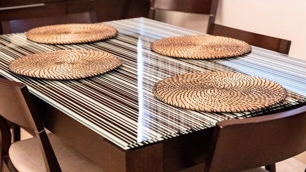 A dining table with four woven placemats and a striped tablecloth. - Céntrico Apartamento en Santa Cruz (Santa Cruz de Tenerife)