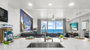 Una cocina moderna con una isla grande, vistas al océano y un comedor.