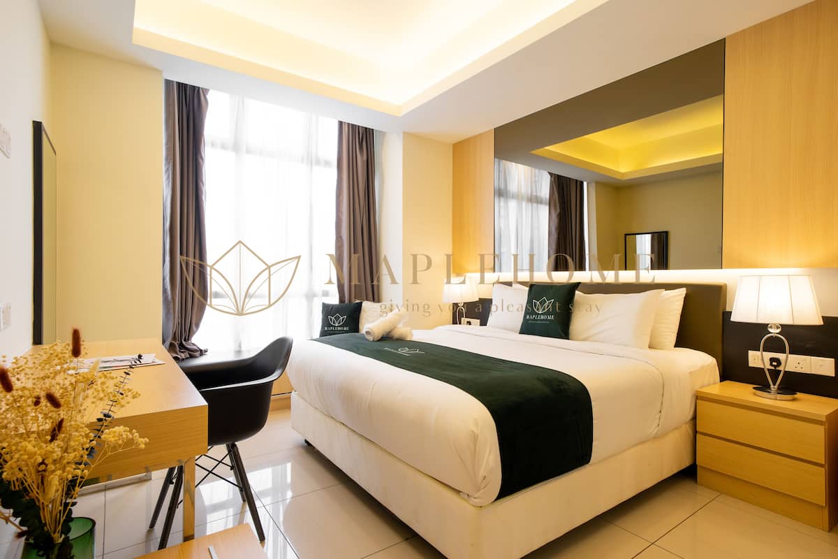 A modern hotel room with a large bed, bedside tables, a desk, and a chair.