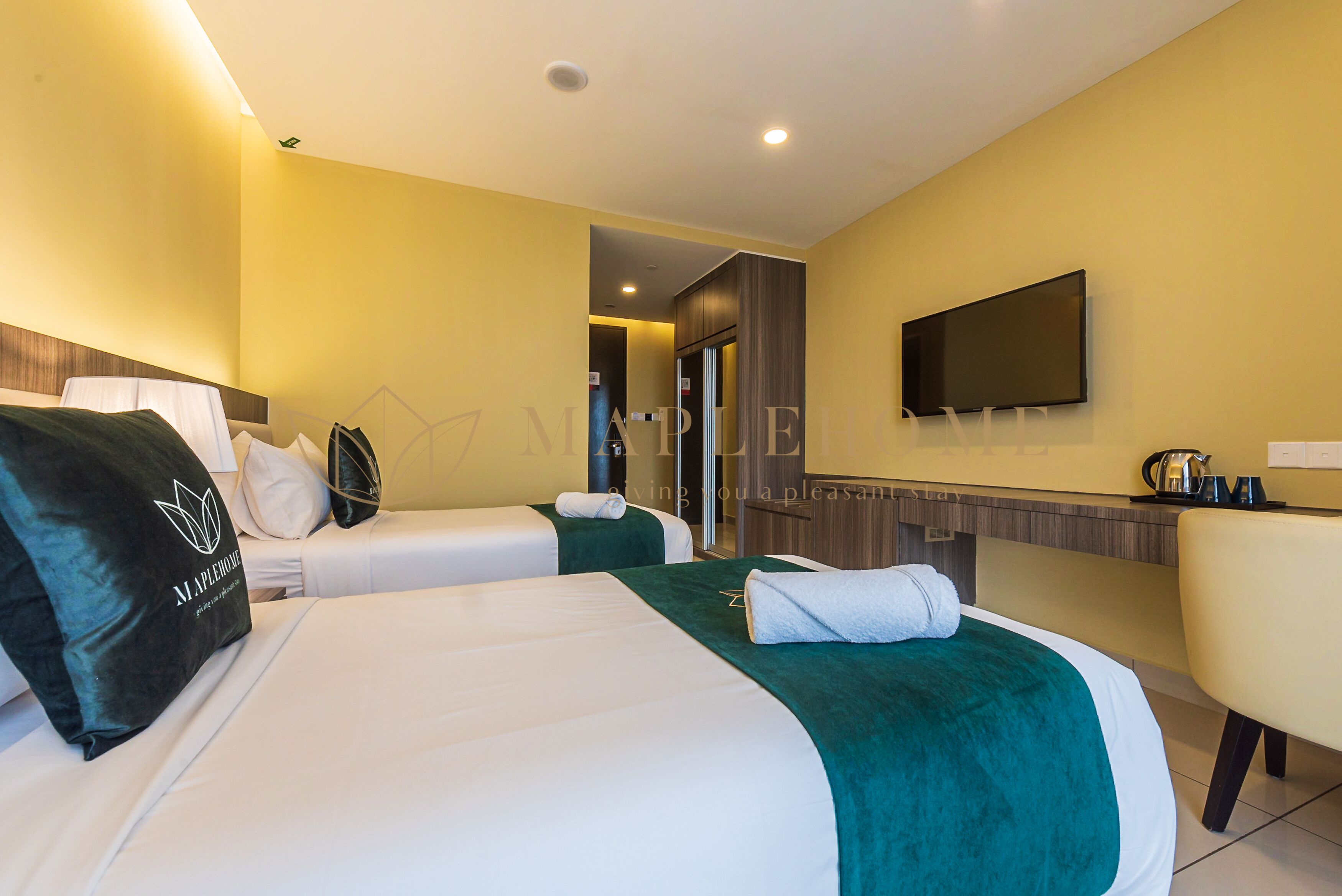 Habitación de hotel con dos camas, un televisor de pantalla plana y una zona de estar.