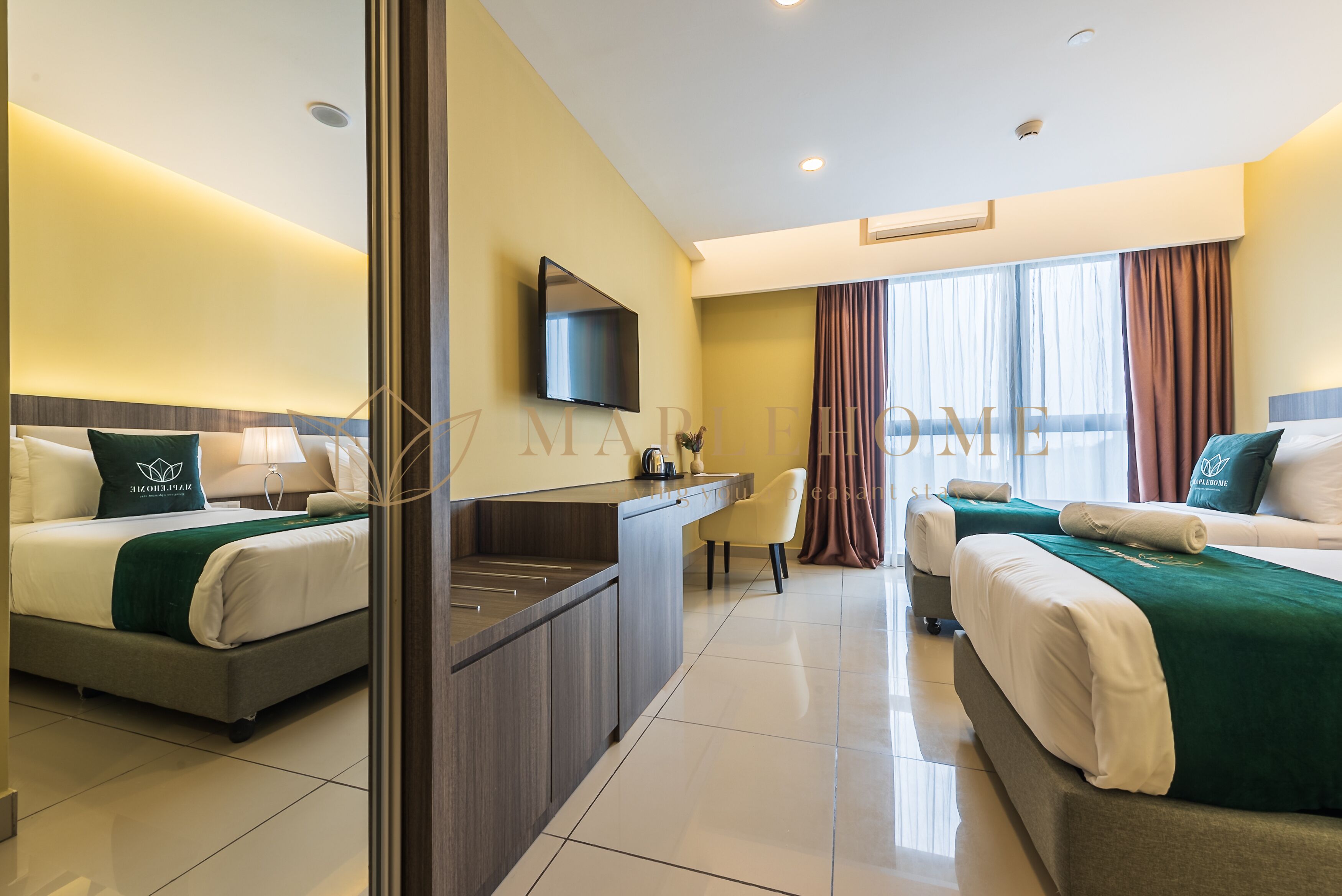 A hotel room with two beds, a desk, a flat-screen TV, and a large window with curtains.