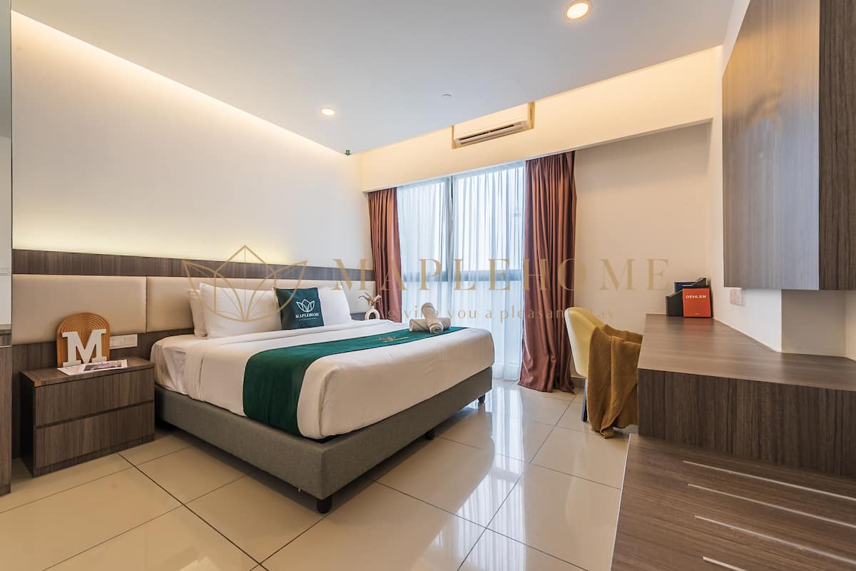 A modern hotel room with a large bed, a desk, and a chair.