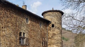 Un edificio de piedra con una torre, rodeado por un campo de flores amarillas.
