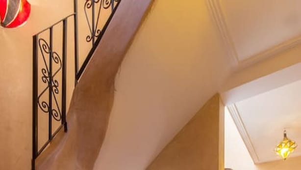 A staircase with ornate metal railings leading to a tiled floor with a geometric pattern. - Riad Colette Exclusif - Médina - Petit déjeuner - Wifi (Marrakech)