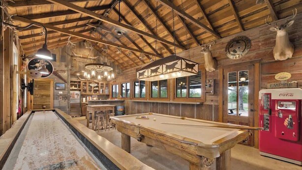 A wooden bar area with a pool table, a billiards table, and a vintage Coca-Cola refrigerator. - Private Ranch Suite-Bar-GameRoom (Fredericksburg)