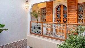 Ein Balkon mit verzierten Holztüren und einem dekorativen Metallgeländer.
