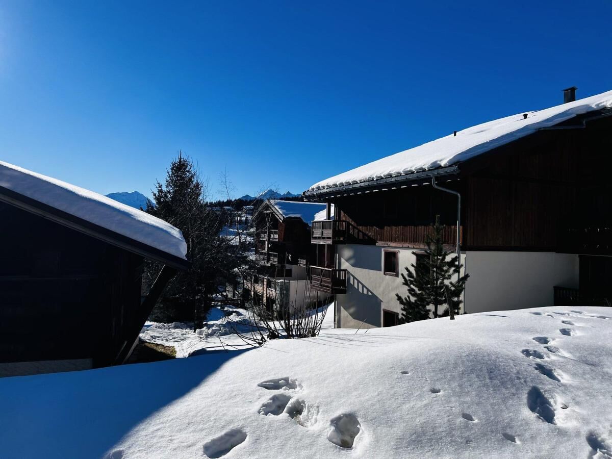 A snow-covered building with a wooden exterior and a balcony.