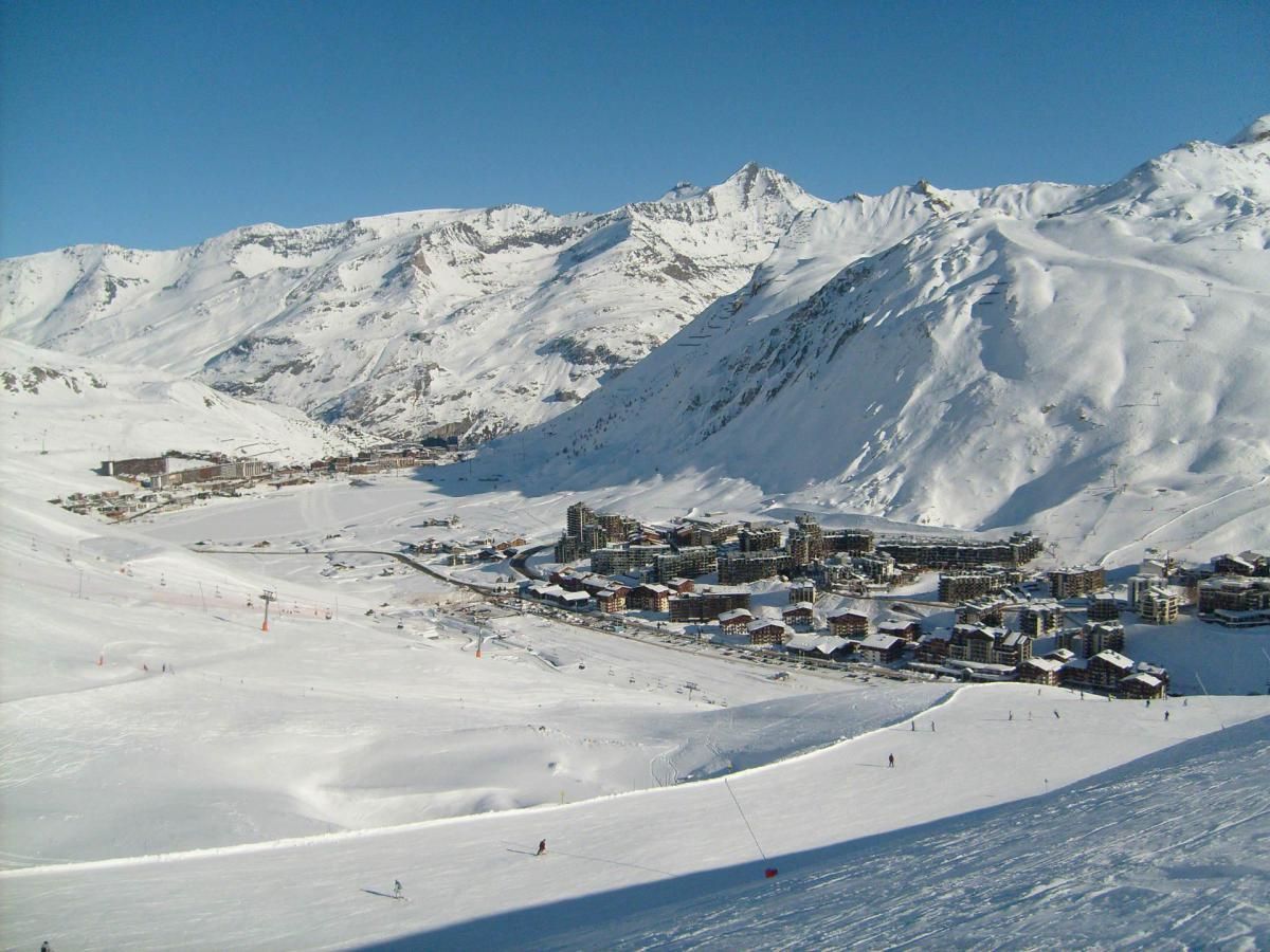 A snow-covered mountain town with ski slopes and buildings.