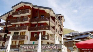 Um hotel com vários andares, varandas e fachada de pedra.
