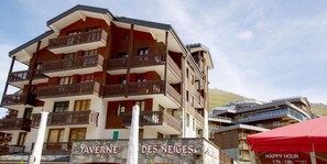 Un hotel a più piani con balconi e facciata in pietra.