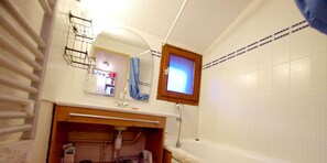 A bathroom with a bathtub, a sink, a mirror, and a window. - 20m from ski slopes, 5th floor, balcony, tv, ski locker, 24m², Tignes (Tignes)