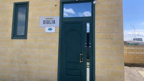 Une porte verte avec une enseigne au-dessus portant l’inscription « GIULIA ».