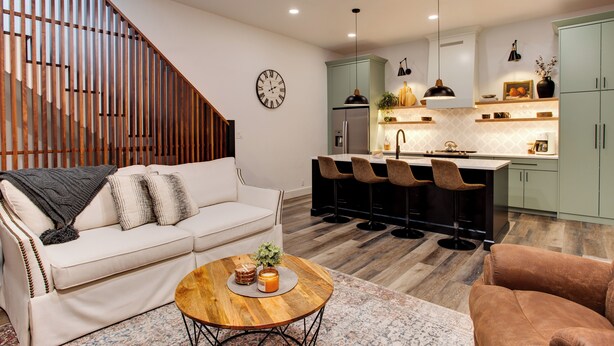 A modern living room with a sofa, coffee table, and a staircase.