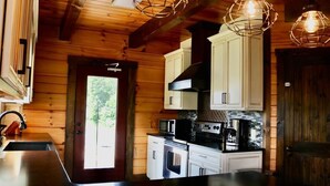 Una cocina moderna con paredes de madera, armarios blancos y una isla grande.