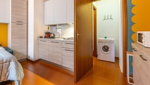 A compact kitchen with a washing machine and a microwave. - -STUDIO ARENA (Verona)