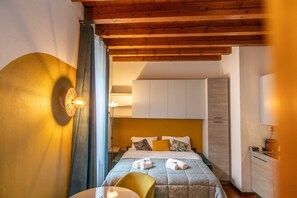 Una habitación de hotel con cama, escritorio y armario.