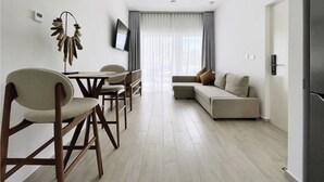 Een moderne woonkamer met een bank, een eettafel en stoelen.
