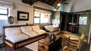 Un baño moderno con una bañera independiente, un mueble de tocador de madera y una cabina de ducha con mampara de vidrio.