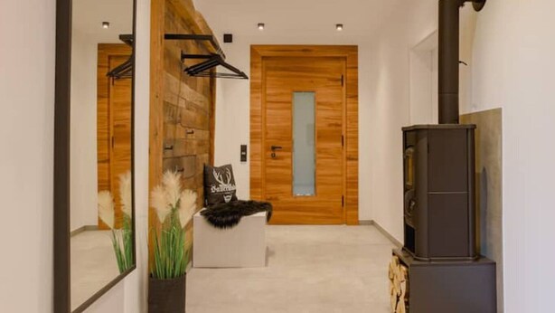 A modern interior with a wooden wall, a fireplace, and a mirror.