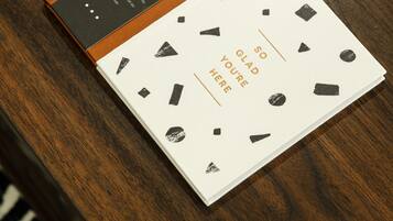 A book with a white cover and black geometric shapes, placed on a wooden surface.