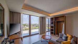 Una sala de estar moderna con un televisor grande, un sofá, una mesa de centro y un armario.