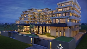 Un hotel de varios pisos con un diseño moderno, con balcones y ventanas amplias.