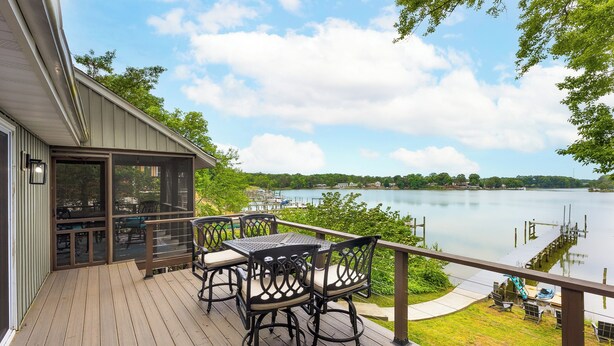 A deck with outdoor furniture overlooking a lake. - River Refresh - Waterfront with Spa on Placid Bay (Colonial Beach)