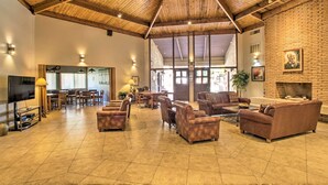 A spacious living area with a high wooden ceiling, a fireplace, and comfortable seating. - Scottsdale Vacation Rental: 1 Mi to Old Town! (Scottsdale)
