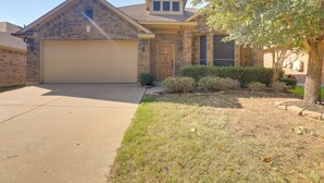 A residential house with a garage, brick facade, and a well-maintained lawn. - 6 Mi to Dtwn Mansfield! Family Getaway w/ Patio (Mansfield)