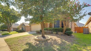 A residential area with a tree in a circular planter, a brick house, and a wooden fence. - 6 Mi to Dtwn Mansfield! Family Getaway w/ Patio (Mansfield)