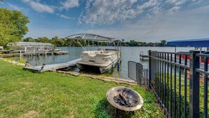 A lakeside dock with a boat, a covered seating area, and a grill. - Lakefront Wisconsin Escape w/ Boat Dock & Kayaks! (Oconomowoc)