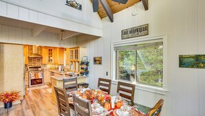 A spacious kitchen with wooden cabinets and a dining area with a table set for six. - 2 Mi to Skypark at Santa's Village: Family Cabin (Lake Arrowhead)