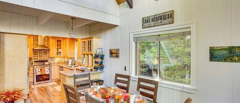 A spacious kitchen with wooden cabinets and a dining area with a table set for six.