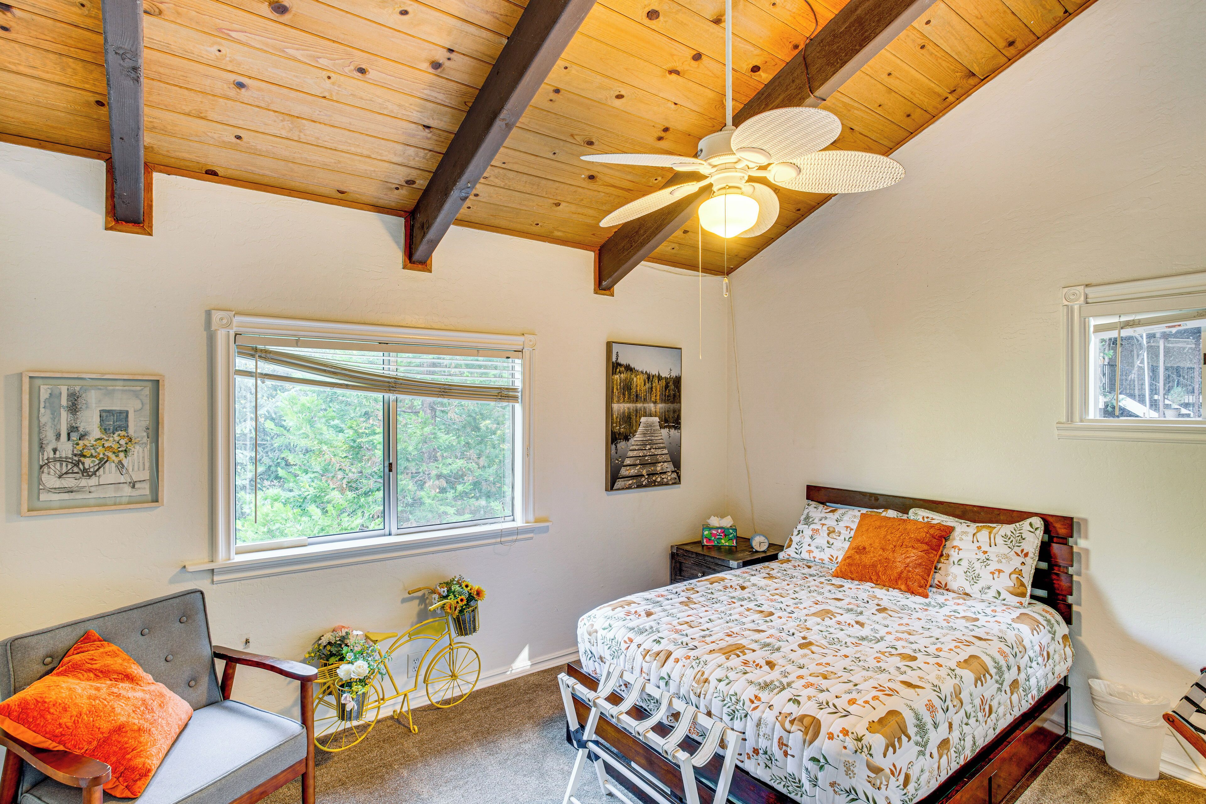 A bedroom with a bed, a chair, a bicycle, and a window.