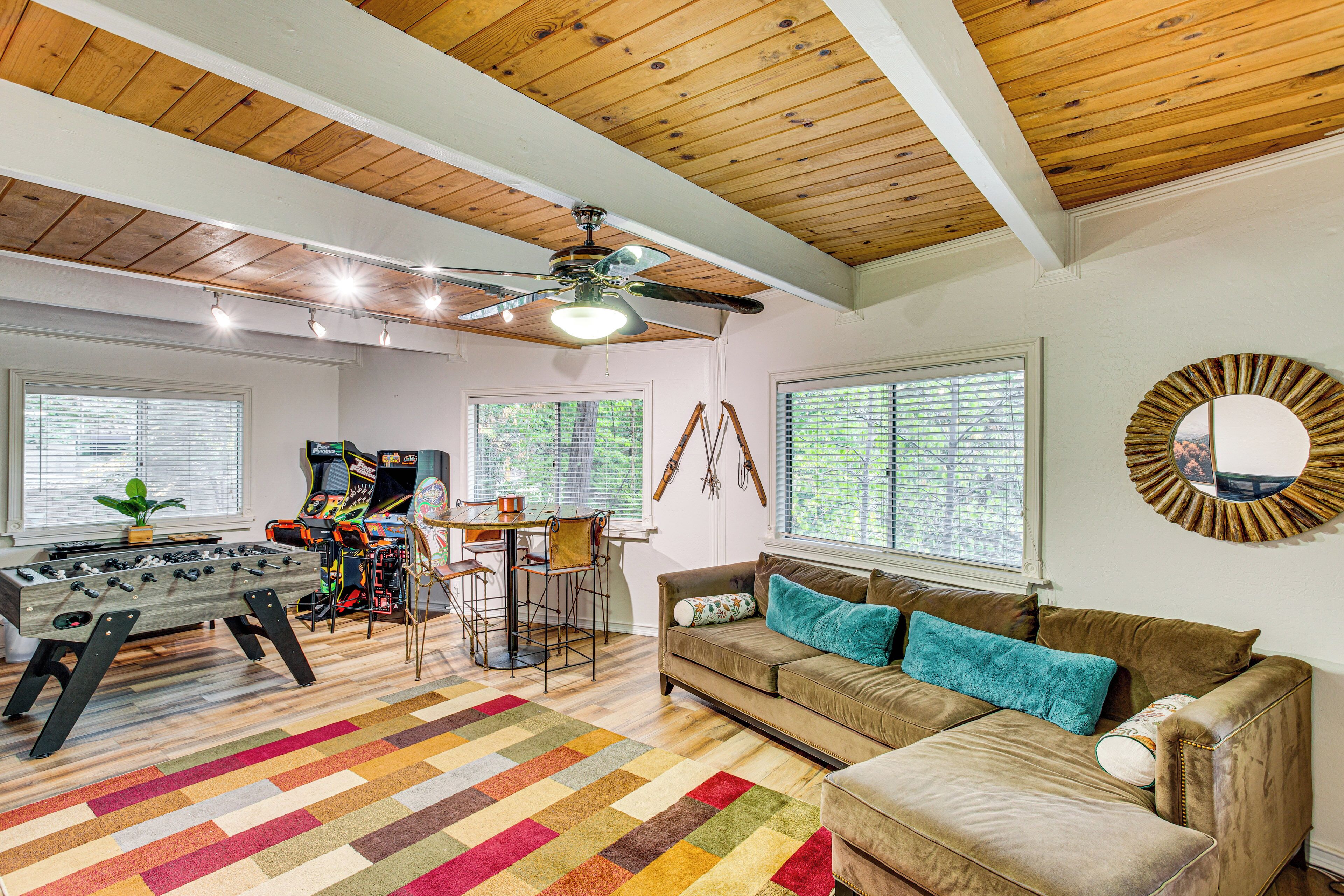 A cozy living room with a foosball table, a sofa, and a ceiling fan.