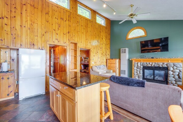 Una cocina amplia con armarios de madera, una isla grande y una chimenea de piedra.