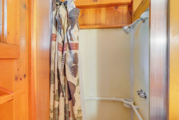 A wooden cabin bathroom with a shower and toilet.
