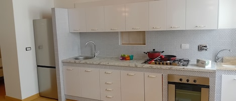 コンフォート アパートメント | 専用キッチン | 大型冷蔵庫、オーブン、コンロ、調理器具と食器