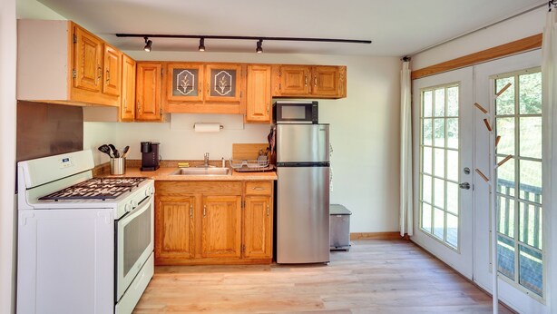 A kitchen with wooden cabinets, a stainless steel refrigerator, and a built-in oven.