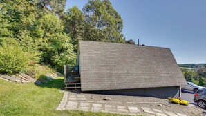 A modern house with a sloped roof, surrounded by a grassy area and trees.