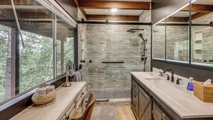 A modern bathroom with a glass shower enclosure, a large mirror, and a vanity with a sink. - Cozy & Chic Lake Arrowhead Cabin w/ Deck! (Lake Arrowhead)