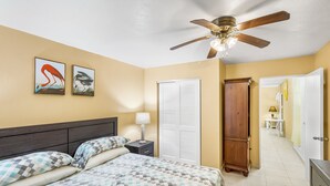 A bedroom with a bed, nightstand, ceiling fan, and artwork on the wall. - Yours For The Asking- Cozy, Caribbean, Condo 2 Bedroom Condo by RedAwning (Christiansted)