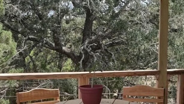 A wooden deck with a round table and two chairs.