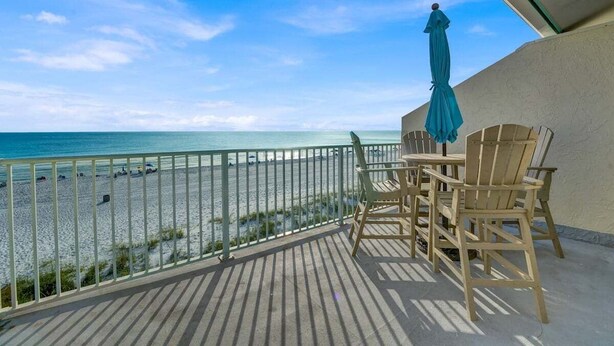 Ein Balkon mit Blick auf Strand und Meer.