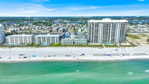 Ein Strandhotel mit mehreren Gebäuden, einem Strand und freiem Blick auf den Ozean.