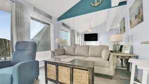 Ein modernes Wohnzimmer mit Sofa, Sessel und Couchtisch.